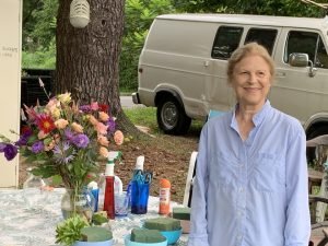 Connie Gillen stands in front of her work table where she arranges flowers for a customer